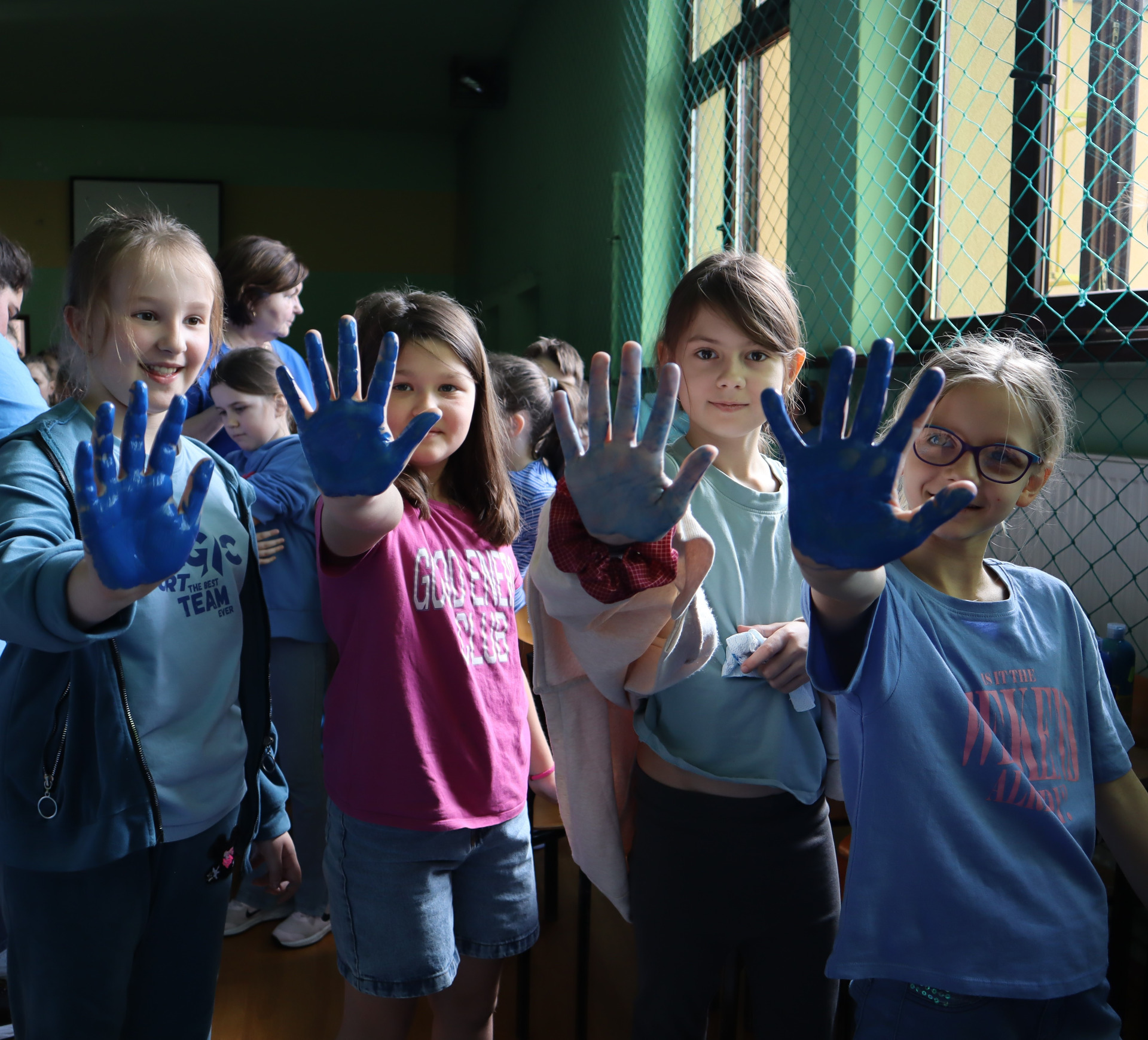 Zdjęcie przedstawia uczniów odbijających dłonie na sercu tolerancji.