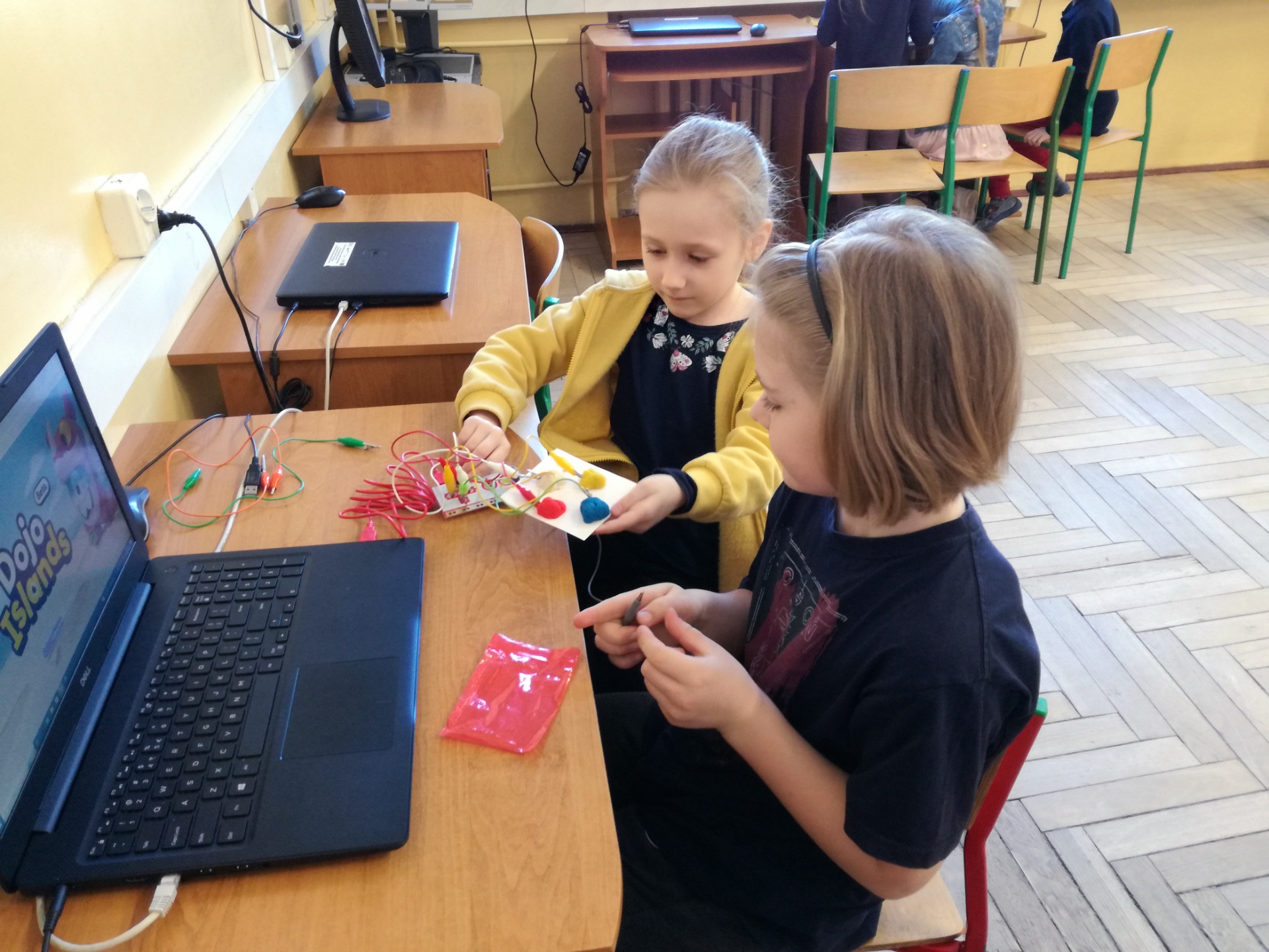 Uczniowie budują joystick z ciastoliny i podłączają go do płytki Makey Makey, a następnie używają joysticka zamiast strzałek i spacji do gry komputerowej