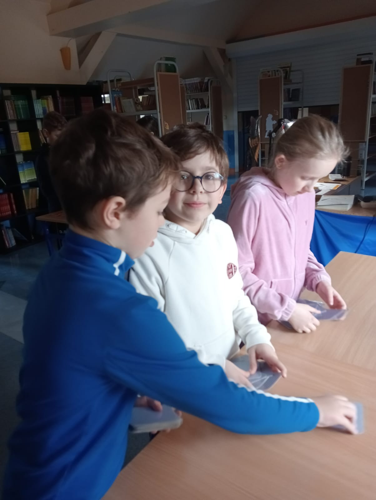 uczniowie grają w grę w bibliotece szkolnej