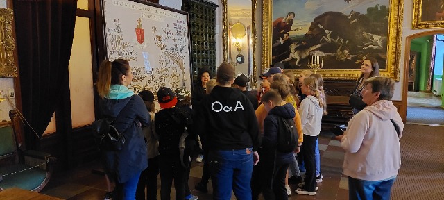 Grupa uczniów przygląda się drzewu genealogicznemu w Pałacu Zamojskich w Kozłówce