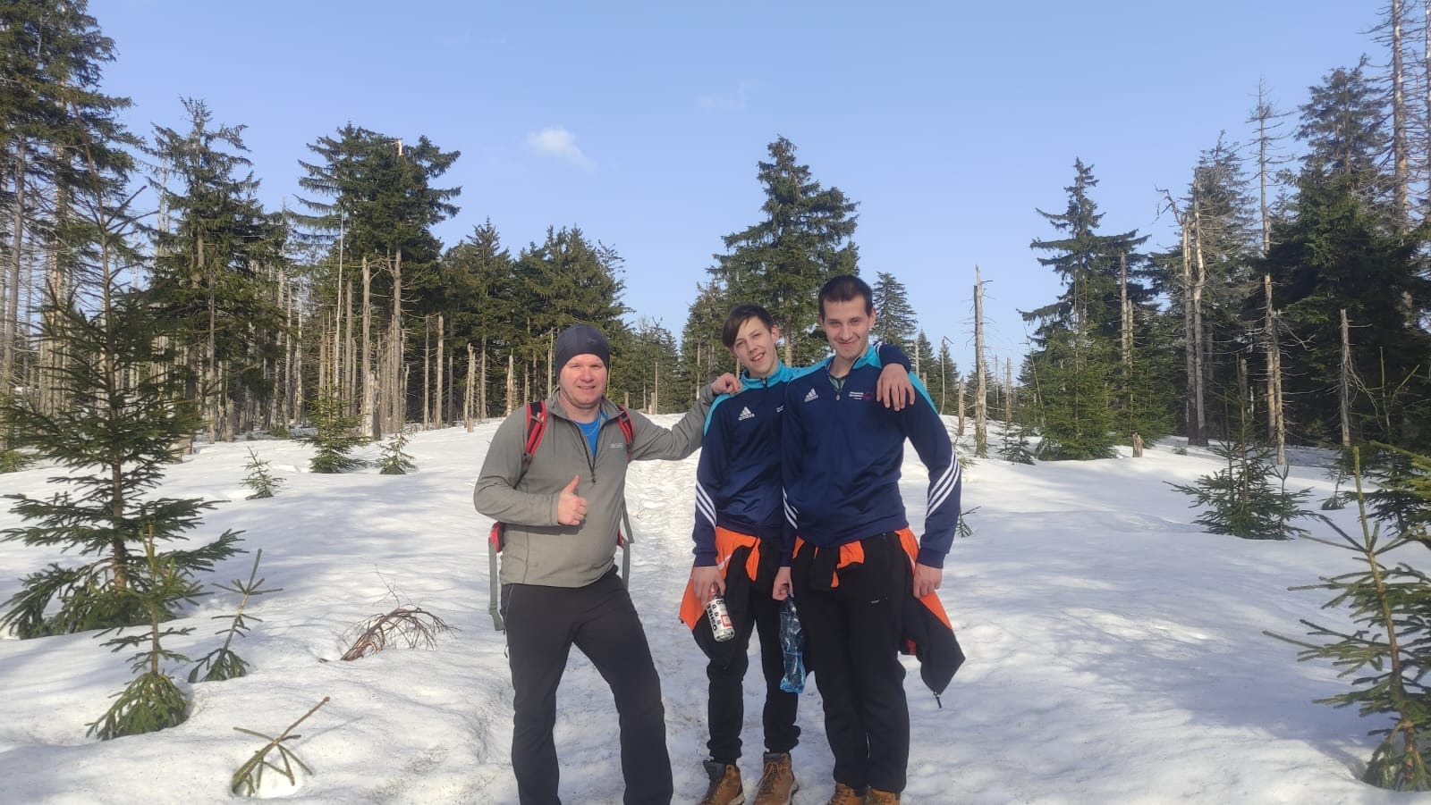 2 uczniów z trenerem na tle zimowej scenerii