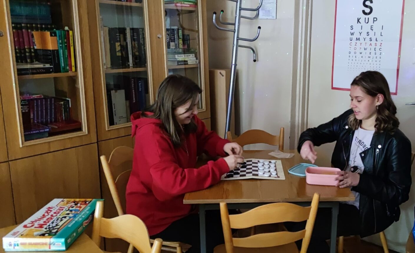 uczniowie grają w gry w bibliotece szkolnej