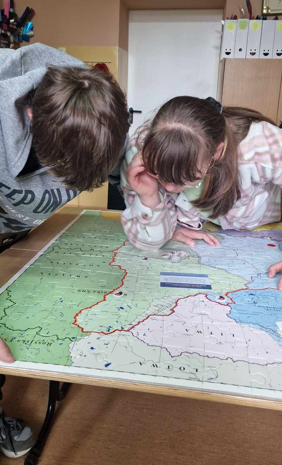 uczniowie czytają historyczną mapę