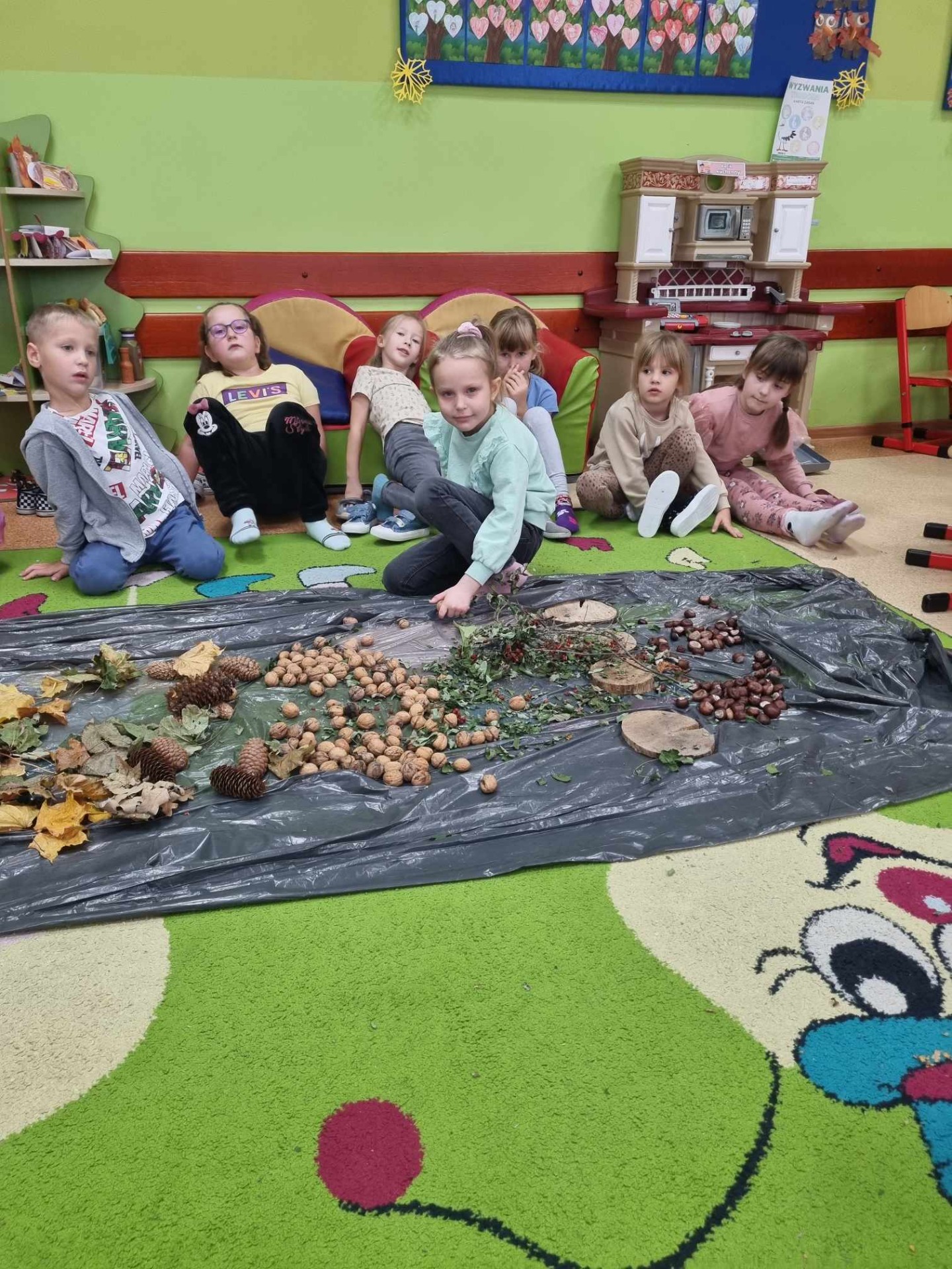 Dzieci budują tor sensoryczny z darów jesieni