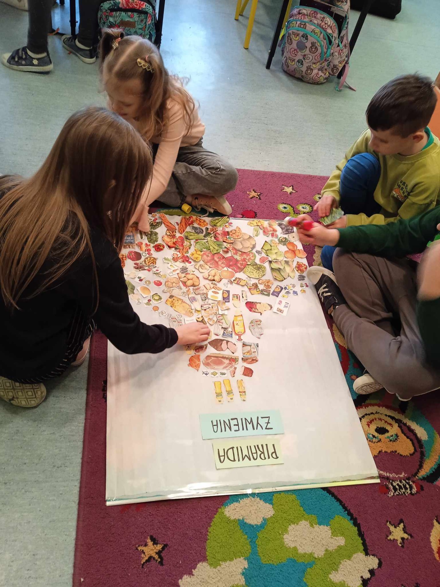 Uczniowie układają piramidę żywieniową.