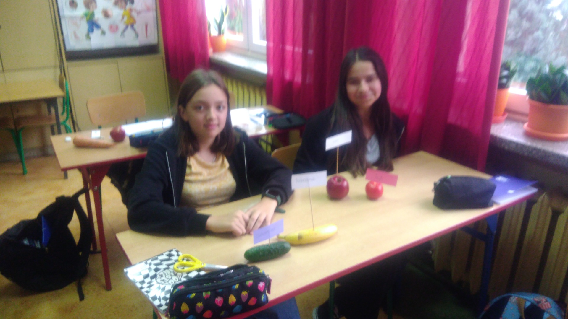 Uczennice klasy V b na zajęciach innowacyjnych z języka angielskiego, prowadzonych przez panią Renatę Modras, etykietujące owoce i warzywa.