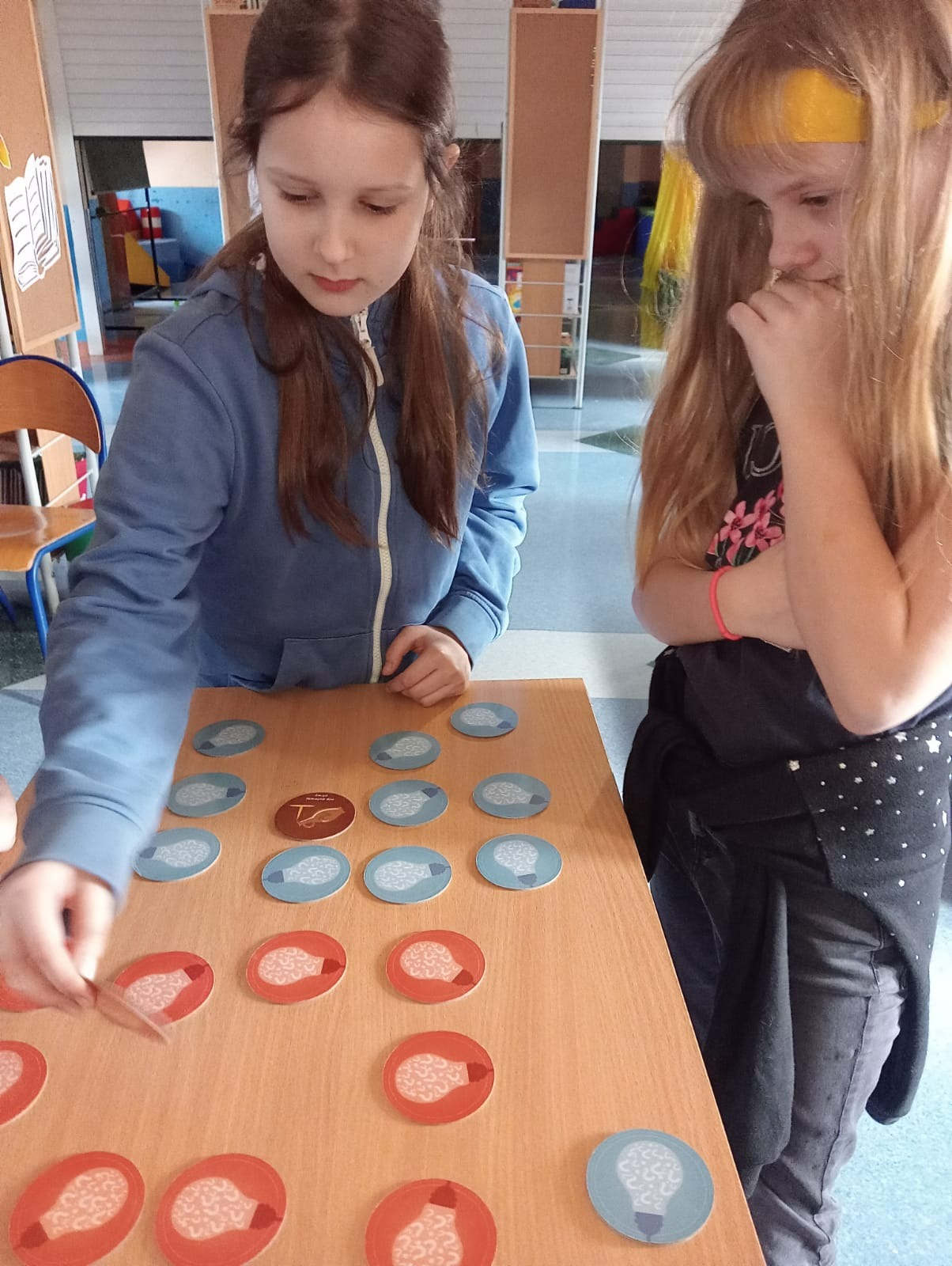 Tekst alternatywny: uczniowie grają w grę w bibliotece szkolnej