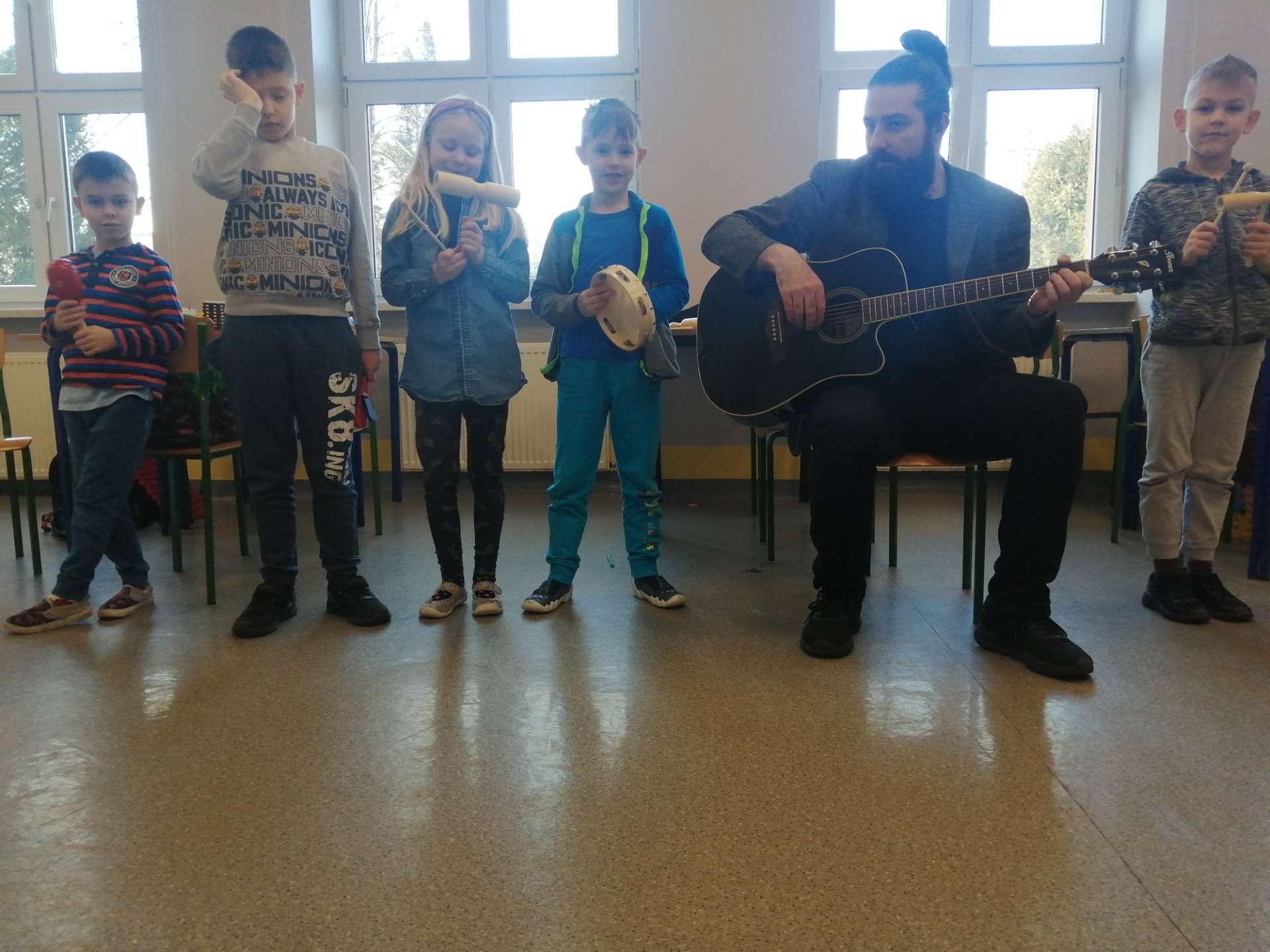 Uczniowie podczas zajęć z nauczycielem muzyki